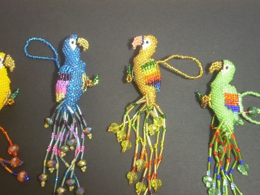 Hangable 3-D parrots of seed beads.